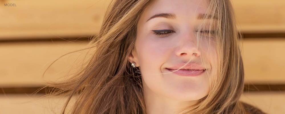 Young Caucasian Woman Closing her Eyes with Hair in her Face