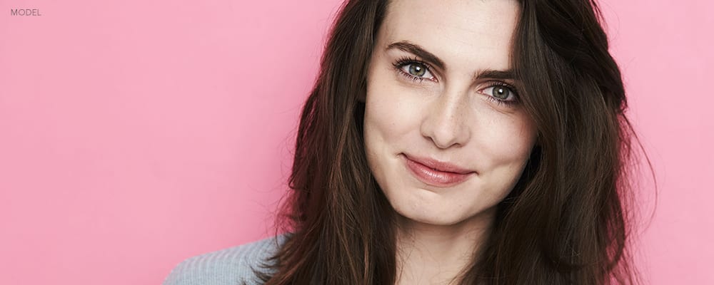 Headshot of Brunette Woman with a Pink Backdrop