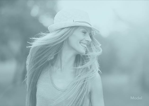 Female Model Smiling and Wearing a Hat with a Pale Blue Filter